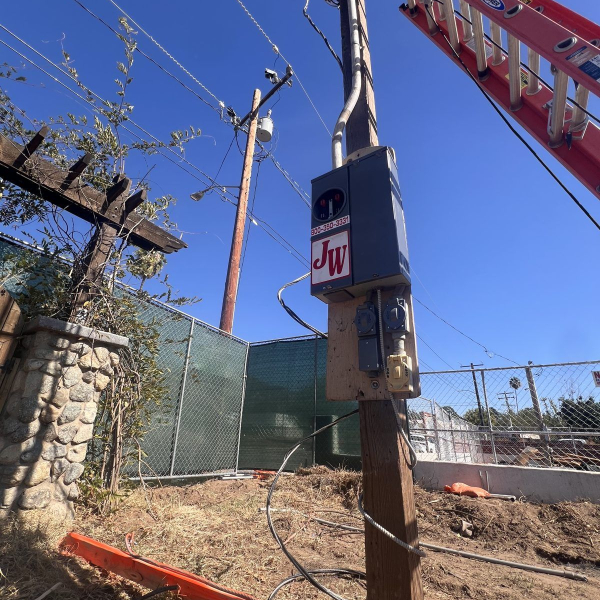 Temporary power meter and outlets – JW Enterprises Close-up of a JW Enterprises temporary power pole showing the meter socket and weatherproof job site outlets