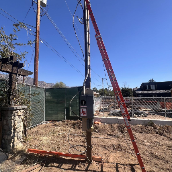 Overhead temporary power pole – JW Enterprises JW Enterprises overhead temporary power pole with meter socket and outlets on a residential construction site